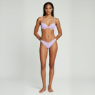 Woman wearing a light purple bikini on a white background